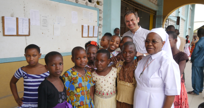 Pfarrer Martin, Sr. Betty und einige Schulkinder