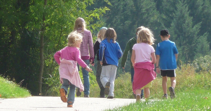 Kinder, die auf einer Forststraße laufen