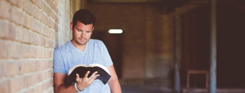 Ein junger Mann liest in der Bibel in einer Kirche