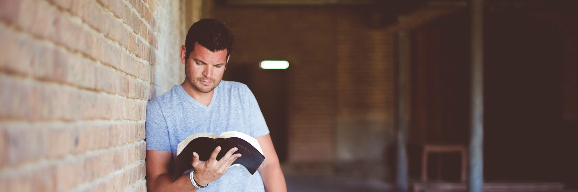 Ein junger Mann liest in der Bibel in einer Kirche