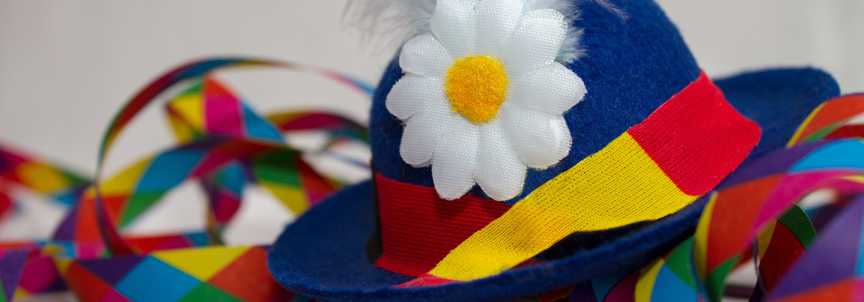 Ein bunter Faschingshut mit Blume und bunte Luftschlangen