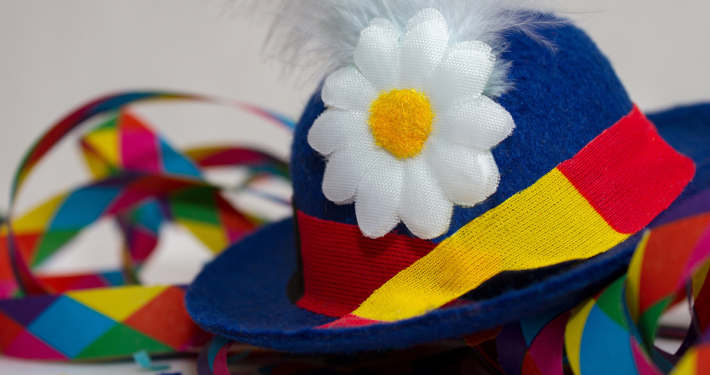 Ein bunter Faschingshut mit Blume und bunte Luftschlangen