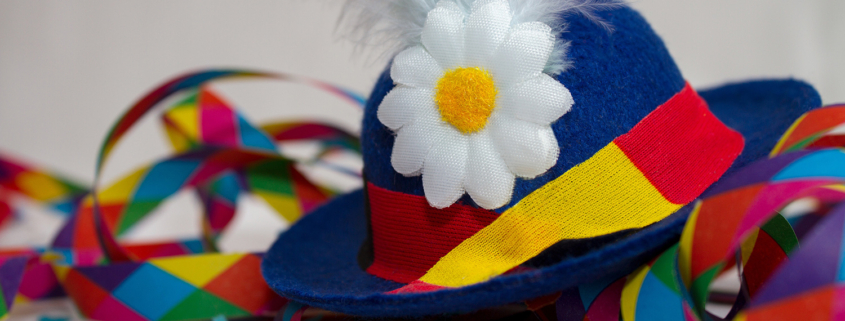 Ein bunter Faschingshut mit Blume und bunte Luftschlangen