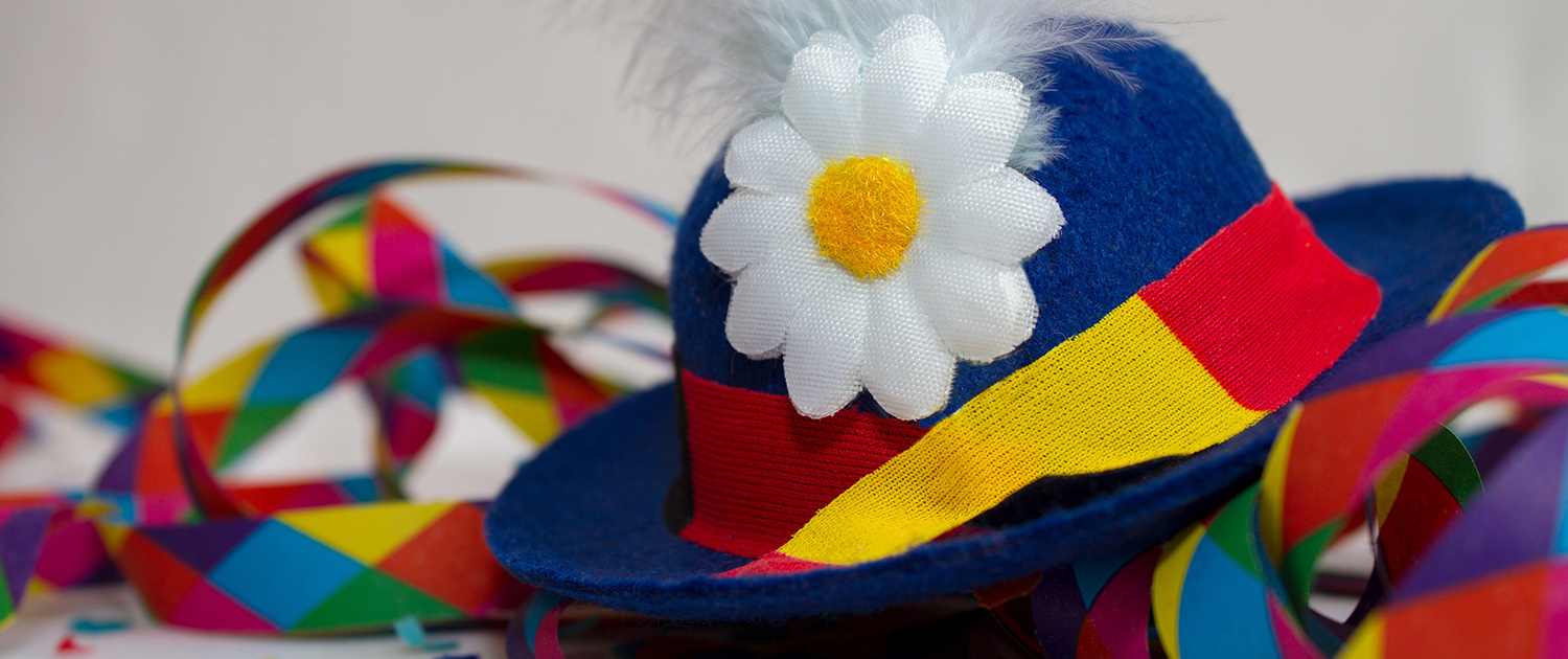 Ein bunter Faschingshut mit Blume und bunte Luftschlangen