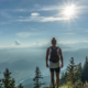 Eine Frau in Sportkleidung steht auf einem Aussichtspunkt in der Natur