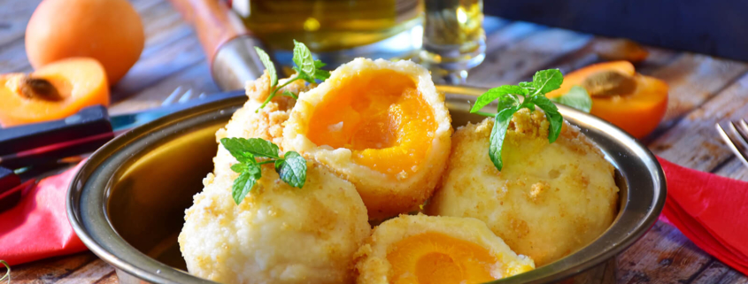 Eine Pfanne mit Marillenknödel steht auf dem Tisch.