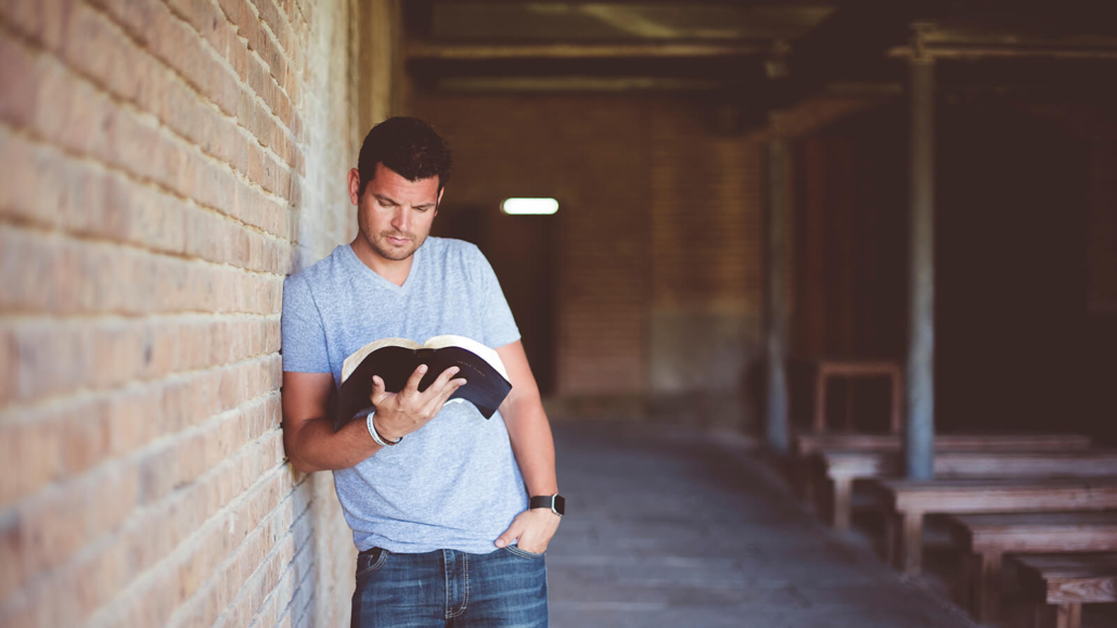 Ein Mann liest die Bibel in einer Kirche